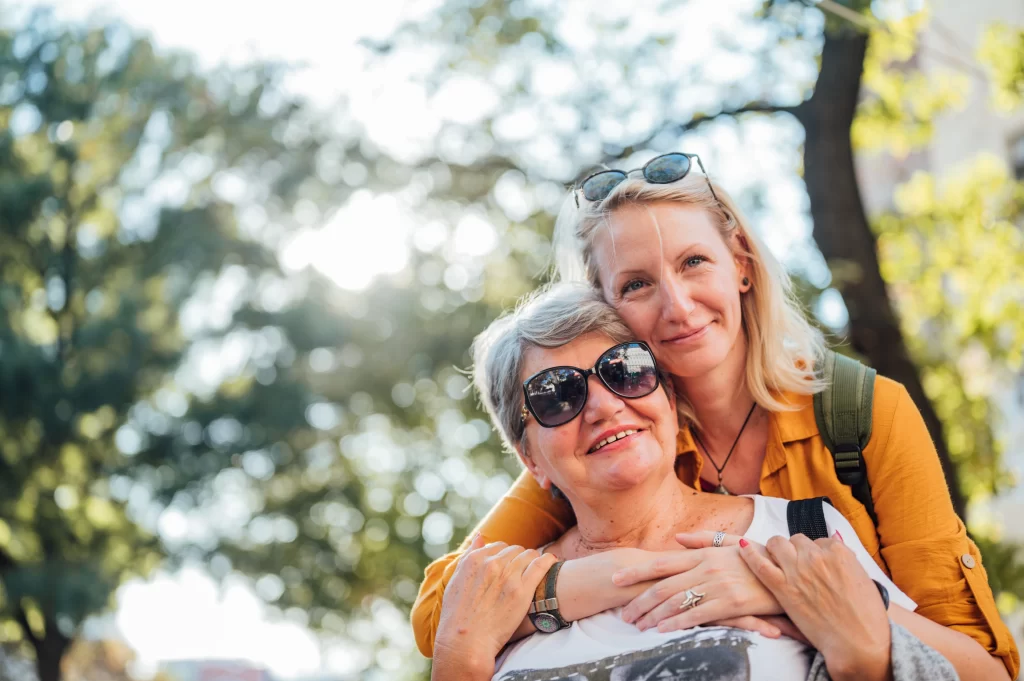 Daughter hugging Mother from behind, smiling emotionally